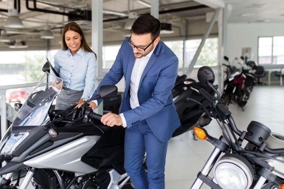 Homem analisando moto em concessionária.