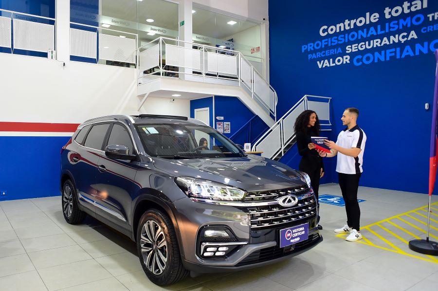 Funcionário de empresa de vistoria veicular mostrando laudo Certicar® para a cliente.