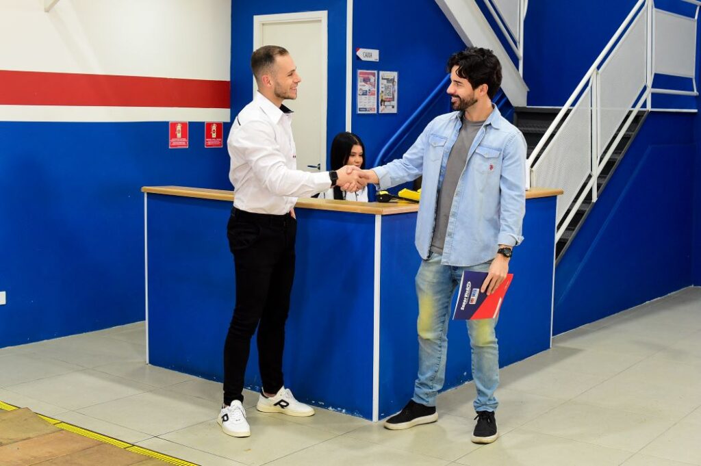 Homens apertando as mãos para fechar vistoria veicular de transferência.