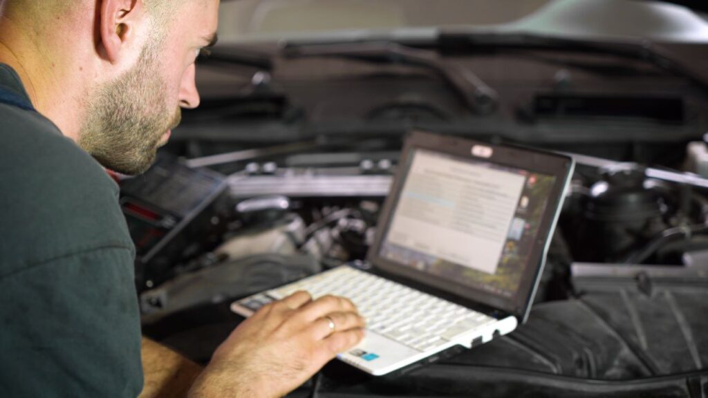 Homem realizando leitura de OBD em carro.