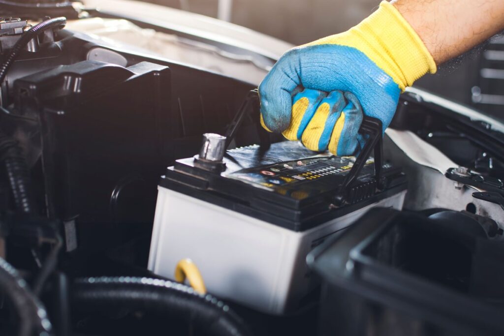 Técnico realiza a troca da bateria de carro, mostrando cuidados para manutenção e aumento da vida útil do veículo.