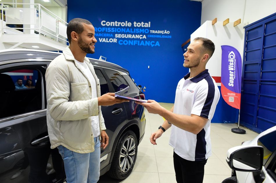 Vendedor e cliente em vistoria automotiva discutindo como montar negócio lucrativo no setor automotivo com franquia consolidada.