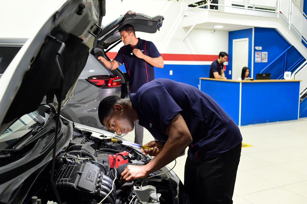 Profissionais realizando inspeções técnicas em carros e motocicleta, em ambiente moderno na franquia de vistoria veicular em Mato Grosso